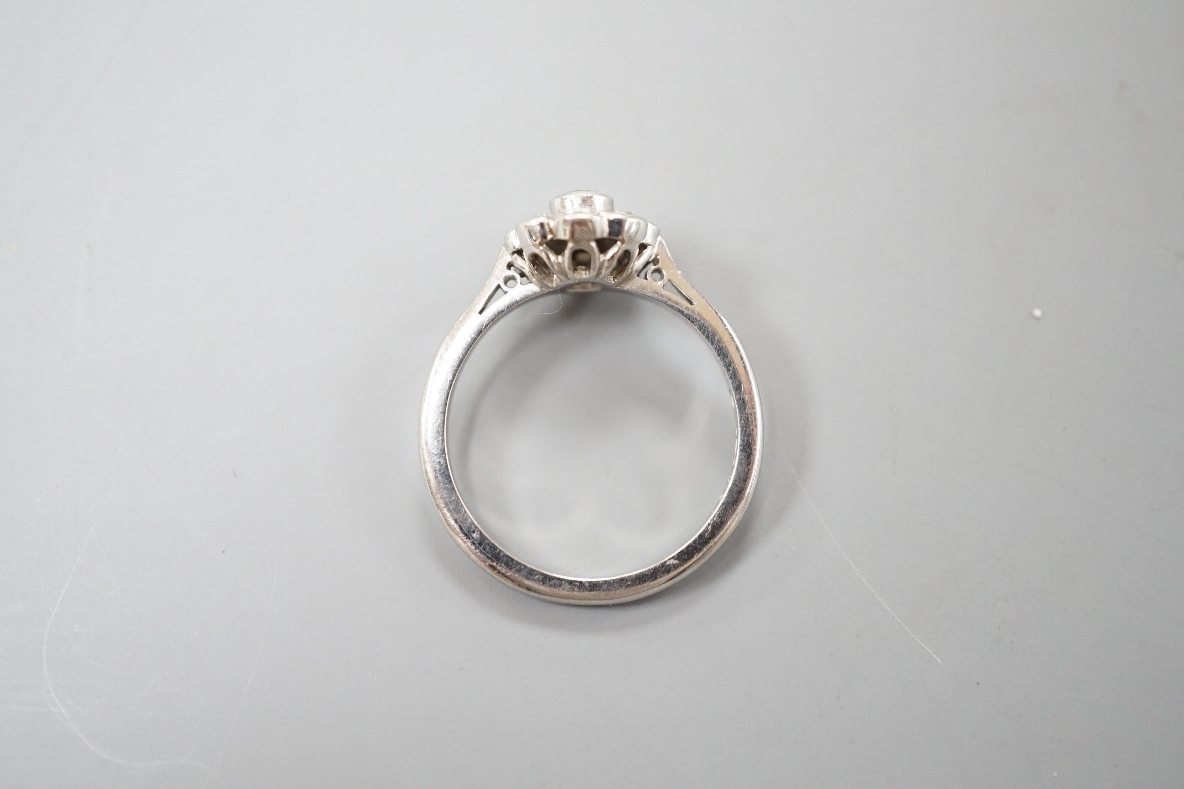 A modern platinum and nine stone diamond set flower head cluster ring, size O, gross weight 5.4 grams.